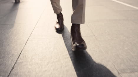 close crop of businessman feet walking in city