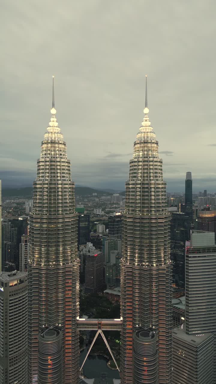 petronas twin towers famous skyscraper skyline building illuminated at night aerial vertical drone