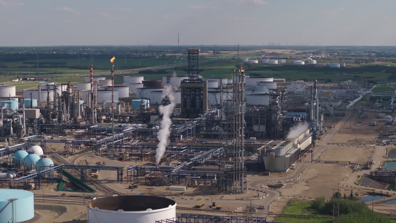 Industrial factory with large chimneys releasing smoke into sky
