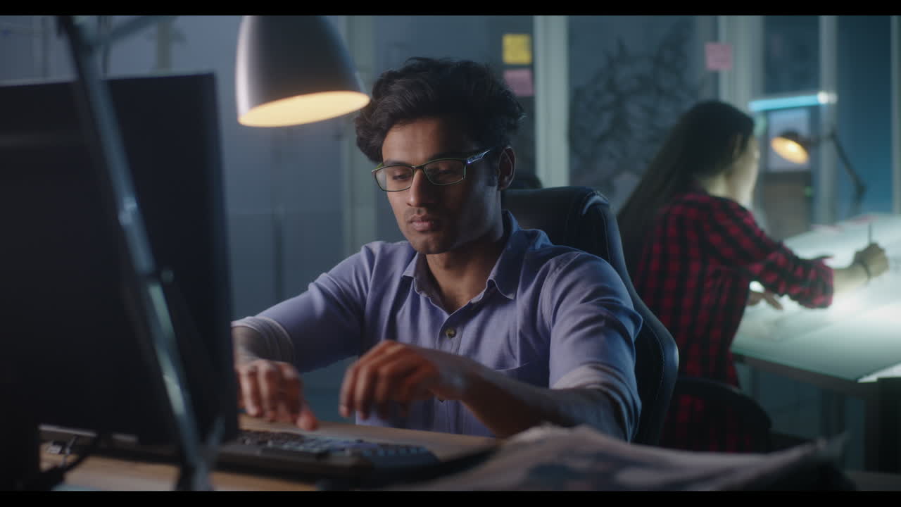 Focused employee working on a computer at night in an office