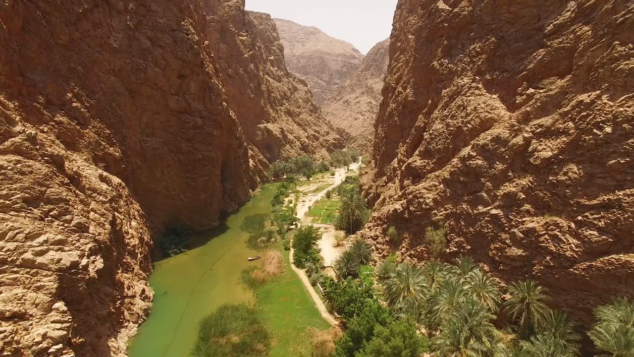 una vista aérea muestra un canal y vegetación entre cañones en wadi shab oman