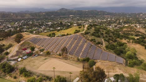 drone view of a solar farm with many panels in southern california with mountains in the distance