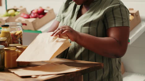 una mujer afroamericana vierte pasta en una bolsa biodegradable.