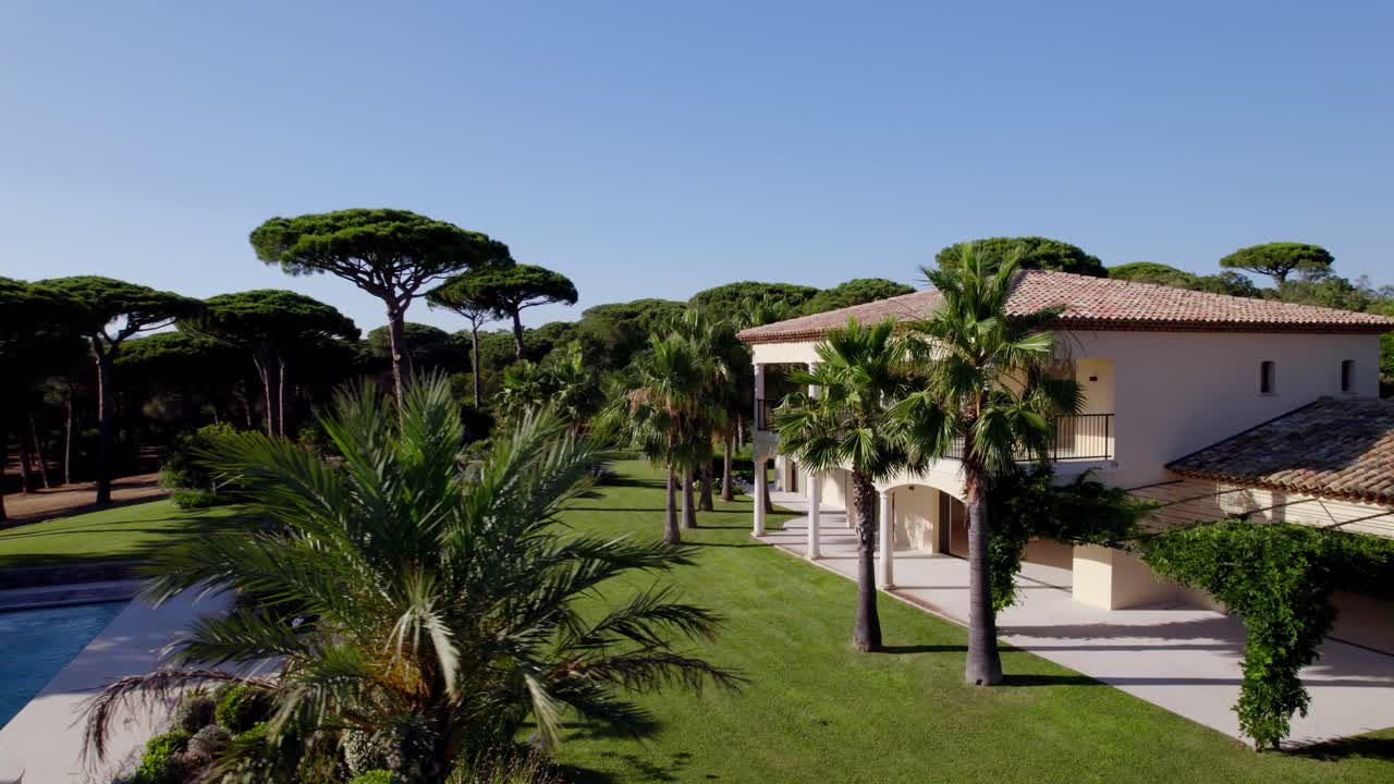 주인이 발코니를 걷고 있는 호화 저택의 회전 샷