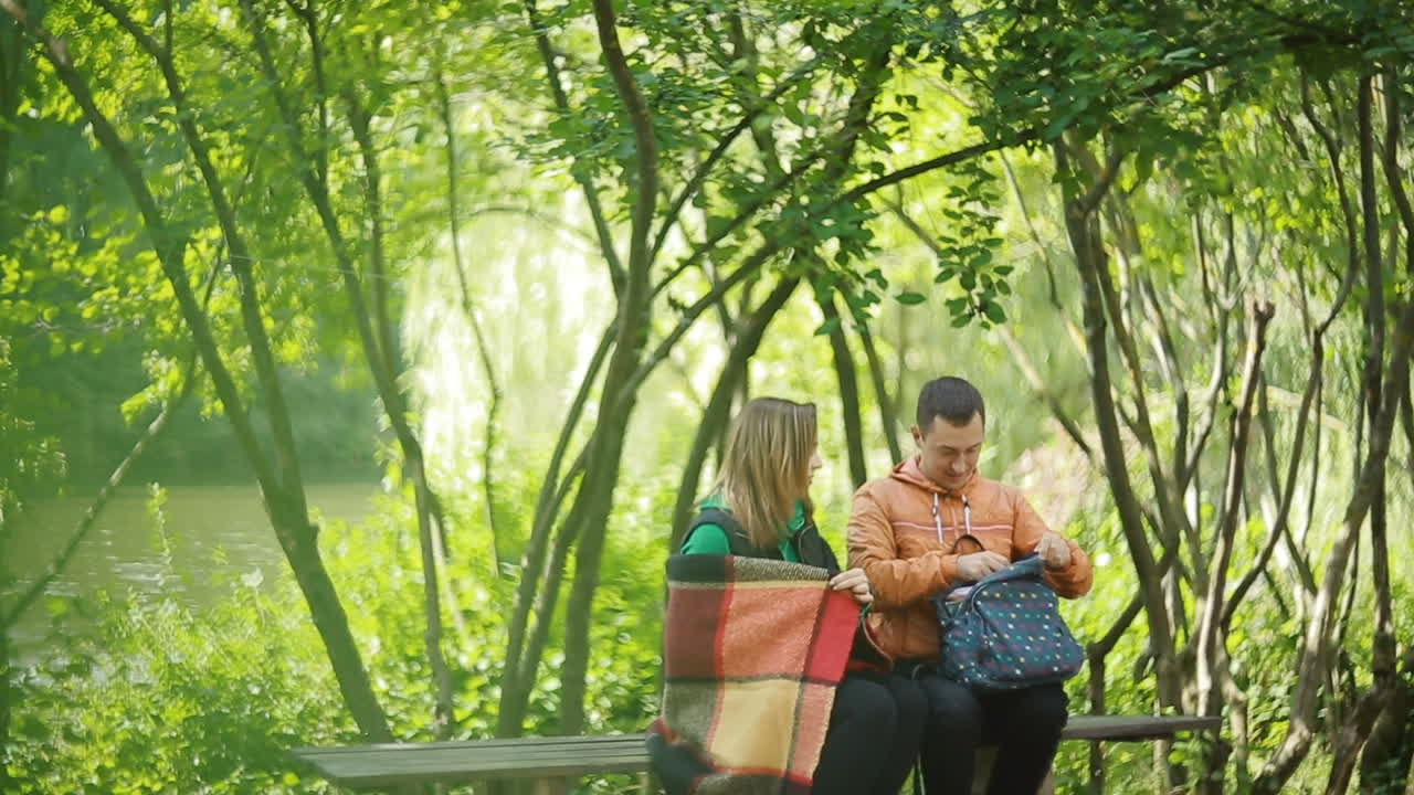 Young couple enjoying weather drinking tea in nature