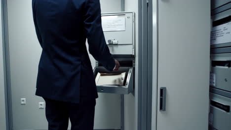 businessman retrieving files from office archive