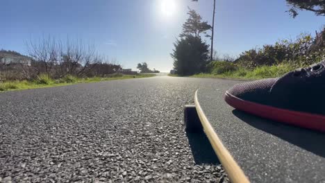 closeup of a skater's board rolling down a road in oregon.