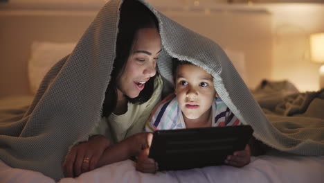 madre e hijo disfrutando del tiempo de la tableta bajo una manta