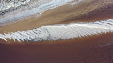 A-top-down-shot-over-a-shallow-brown-colored-creek