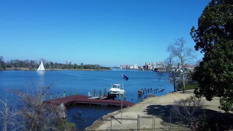 Flying-aerial-view-looking-north-of-Wilmington,-NC-on-the-Cape-Fear-River