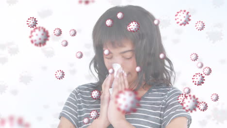 animation of macro covid-19 cells floating over biracial woman sneezing into a tissue