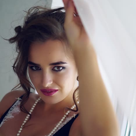 portrait of beautiful young woman posing near the window