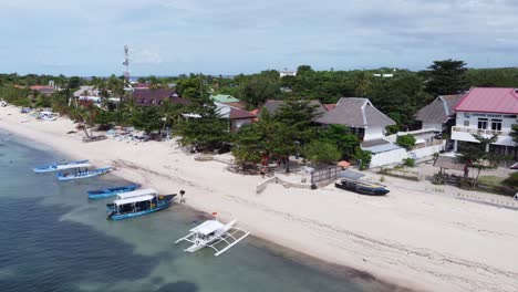 bounty beach dive resorts and shops on malapascua island with locals loading diving boats