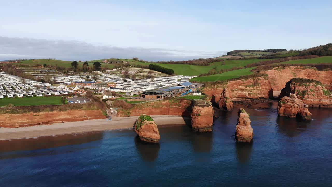 영국 남서부 라드람 베이의 공중 후방 공개 샷은 사암 더미가 주요 특징인 아름다운 해안선을 보여줍니다.
