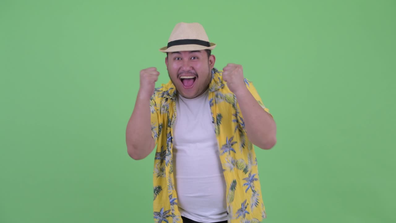 Young handsome overweight Asian tourist man