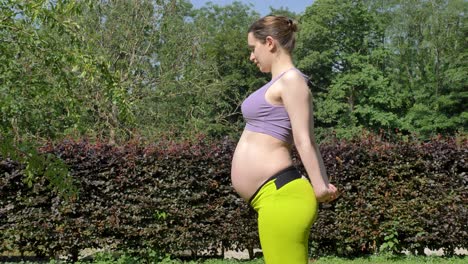 heavily pregnant woman stretching her arms