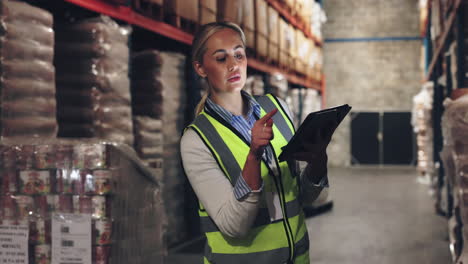 a woman in a warehouse working with a tablet