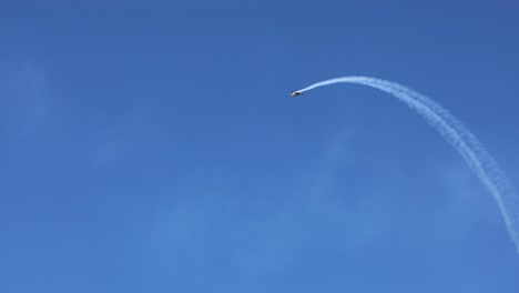 single plane executing aerial maneuvers with smoke trail