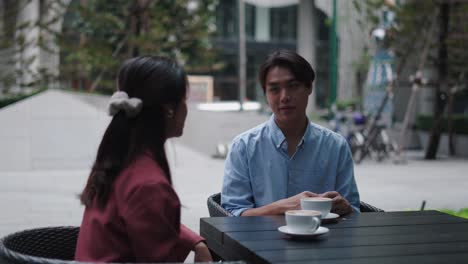 couple having coffee outdoors in a city cafe