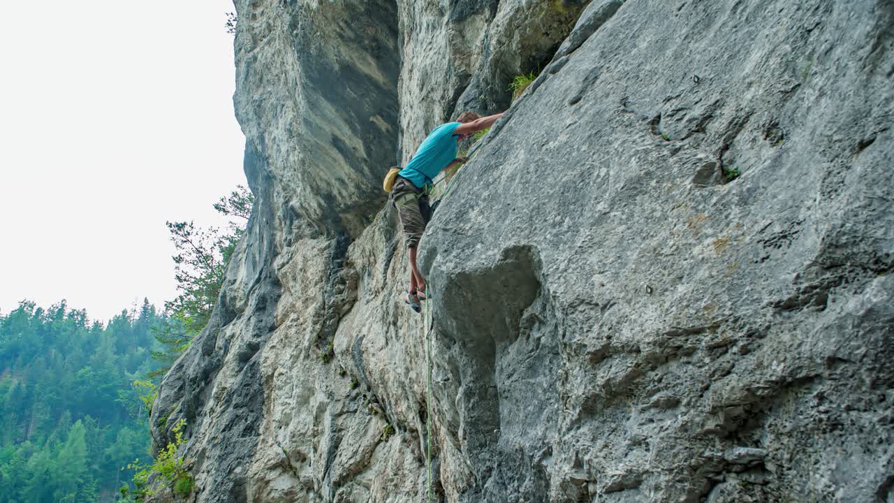young man pro rock climber ascend a vertical cliff. Risk and challenge lover