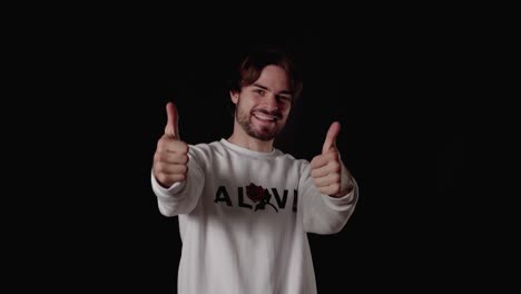 trendy young man giving thumbs up, appreciative gesture, wide, black background