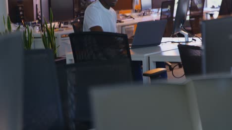 Seitenansicht-Einer-Jungen-Schwarzen-Männlichen-Führungskraft,-Die-Am-Computer-Am-Schreibtisch-Im-Büro-Arbeitet-4k