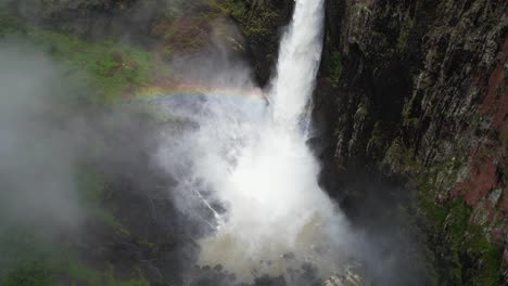 Vista-Aérea-Del-Arco-Iris-Y-La-Niebla-Sobre-Las-Salpicaduras-De-Agua-De-Las-Cataratas-Wallaman,-Australia