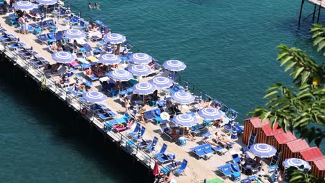 crowded beach pier with umbrellas and sunbathers