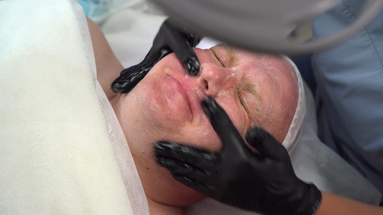 화장실 에서 남자 의 얼굴 에 화장품 마스크 를 적용 하는 화장품 전문가