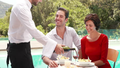 Waiter-pouring-red-wine-in-glass-