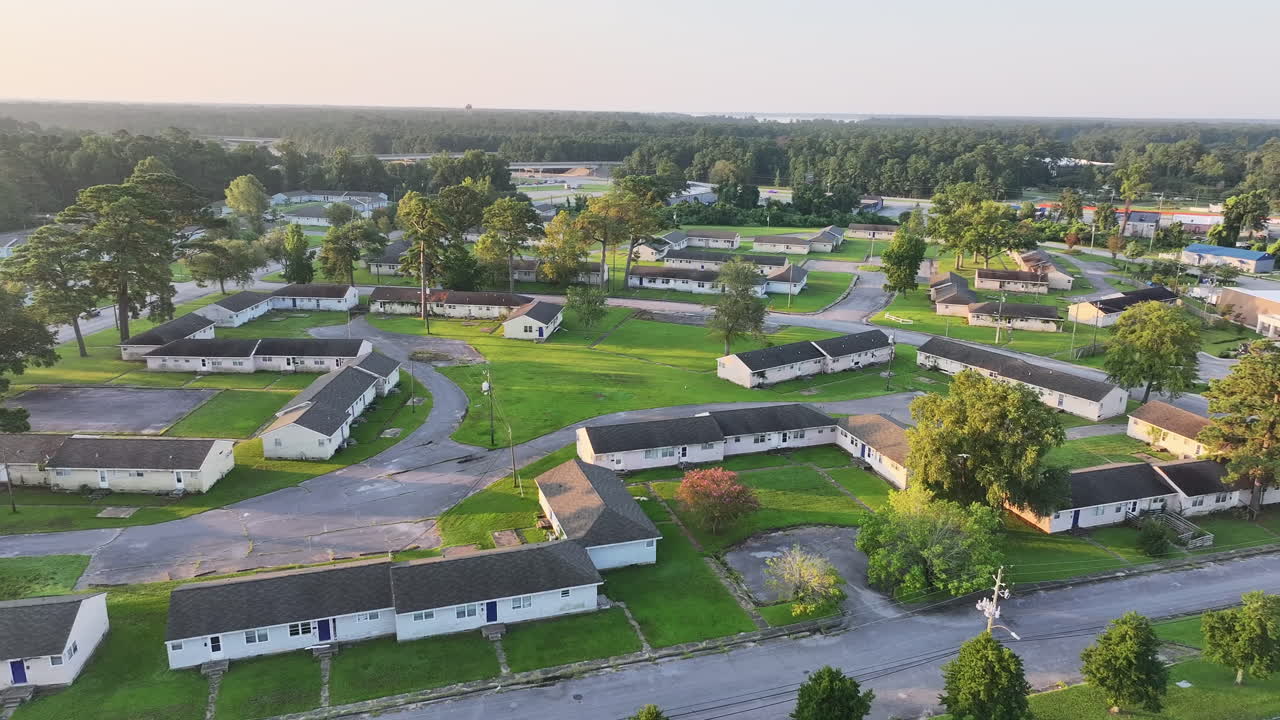 Cinematic drone shot of abandoned apartments with vegetation growing on the buildings, wide aerial footage