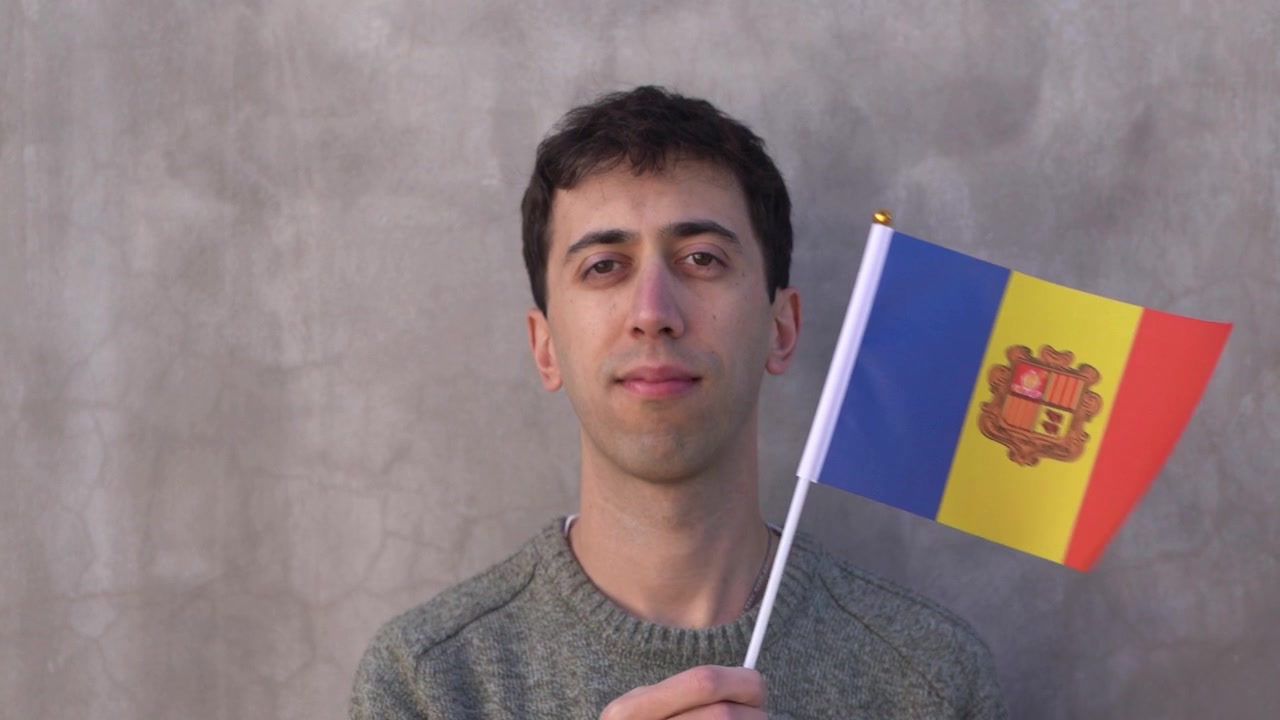 Uomo che sventola la bandiera andorrana. Concetto di patriottismo. Slow motion.