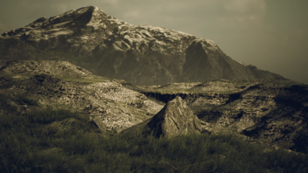 un pico de montaña con nieve en la parte superior y un primer plano rocoso