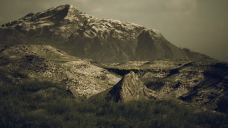 a mountain peak with snow on top and a rocky foreground