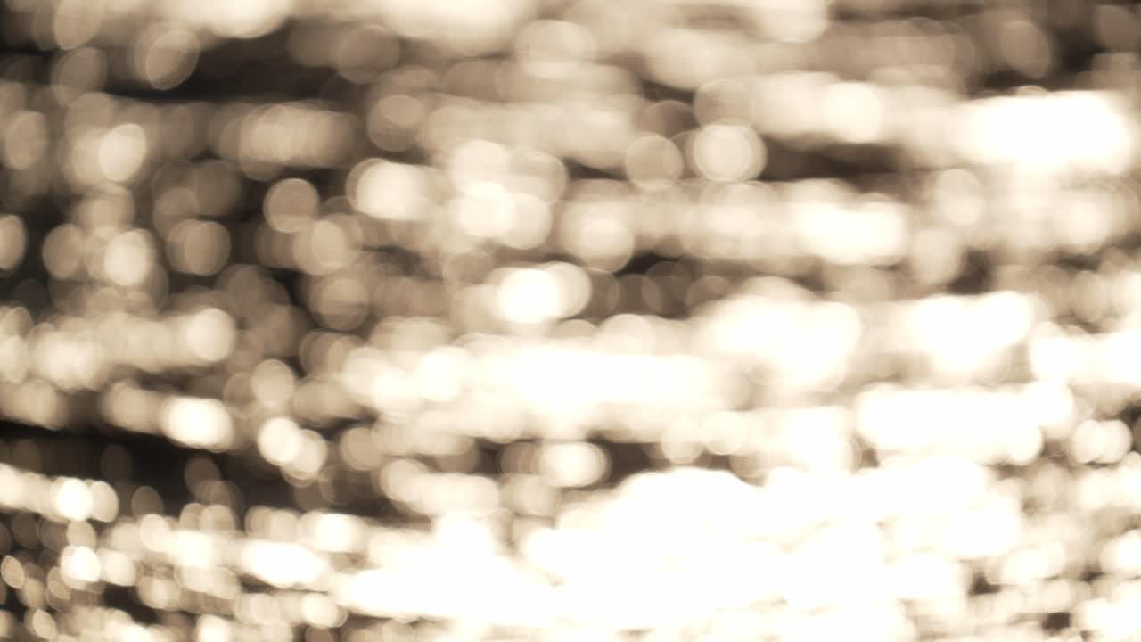 toma de bokeh de la superficie del océano en movimiento al atardecer dorado