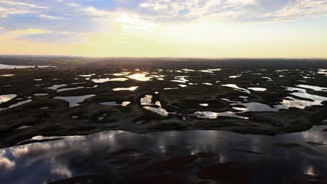 aerial panorama of scattered lakes reflecting a golden sunrise, potholes, washington