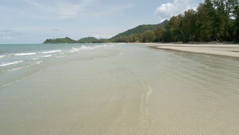 Kamera-Fliegt-Mit-Geschwindigkeit-Am-Tropischen-Strand-Entlang-Mit-Kleinen-Wellen,-Strand-Und-Küste