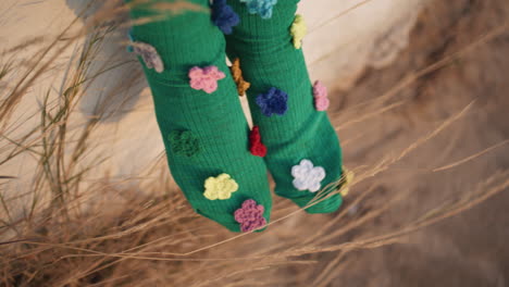 child legs wearing socks with colorful flowers closeup. playful stylish clothing