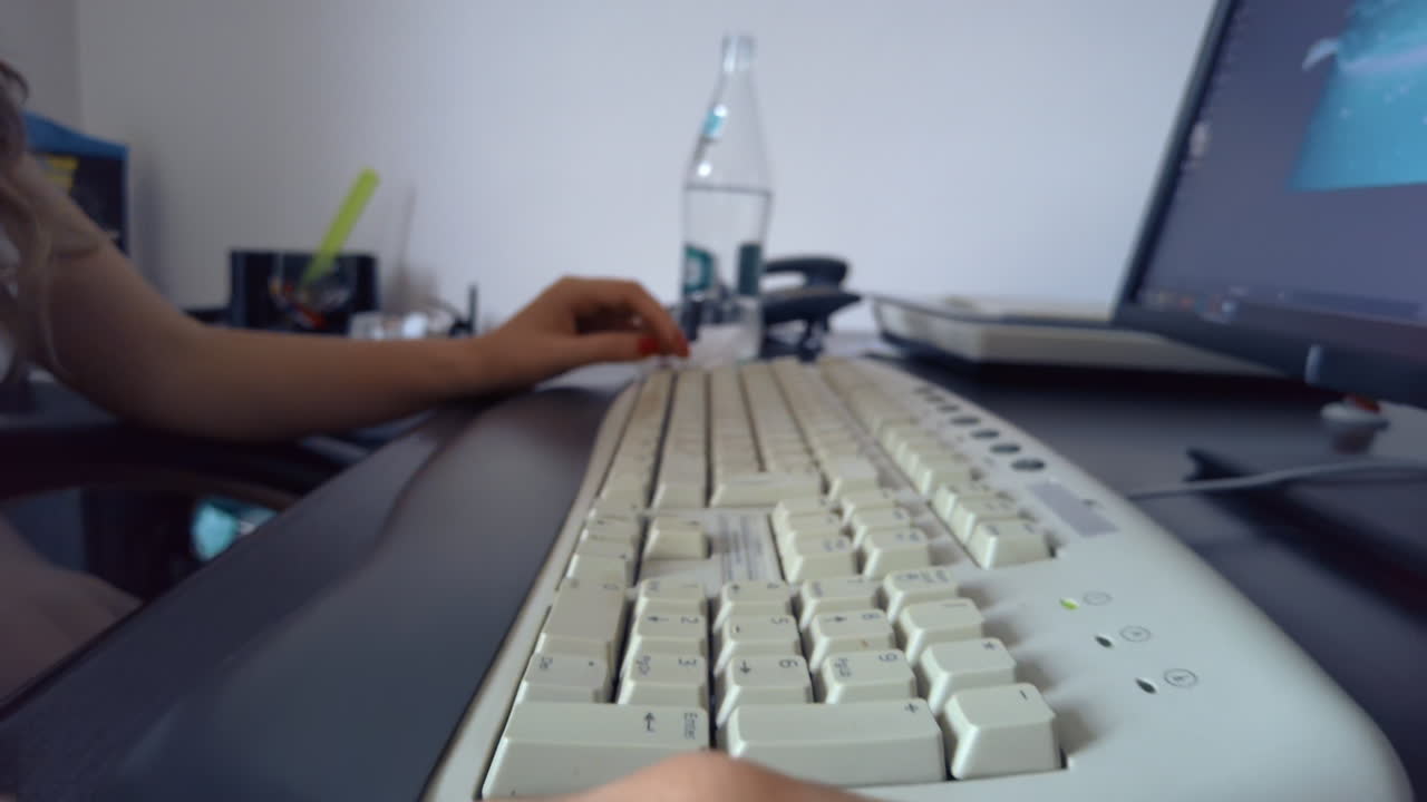 Close up of a woman clicking on a mouse while working on a computer