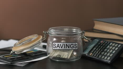 man taking money from glass with family savings