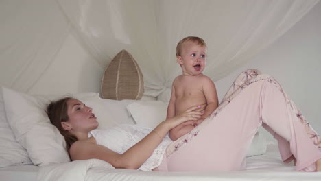 niño pequeño sentado en la madre en la cama