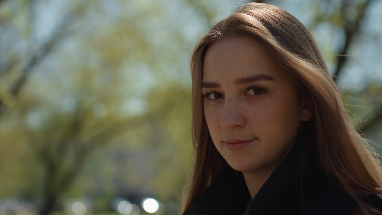 joven y radiante con arreglo floral en el exterior, pose casual de una joven entre árboles tranquilos con flores, joven apacible luciendo un ramo soleado de pie bajo esbeltos abedules