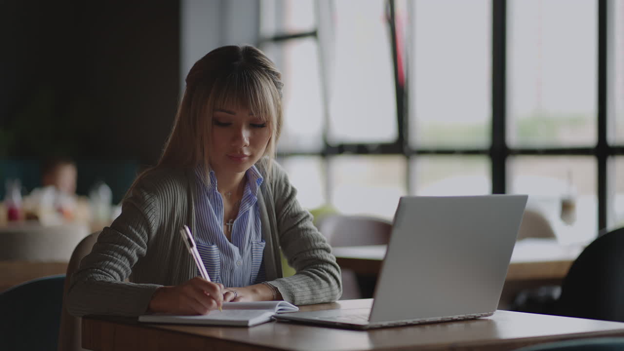 Asian Businesswoman analyzing a graphic of a stock exchange chart. Back of the head of a young female chinese japan japanese korean looking at a stock diagram on the big screen of the laptop