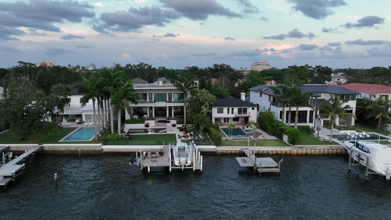 Luxury and exclusive villas with swimming pool and private river access in Tampa, Florida. Aerial lateral wide shot. Private jetty pier in noble district of USA.