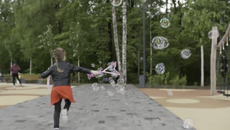 girl playing with bubbles in a park