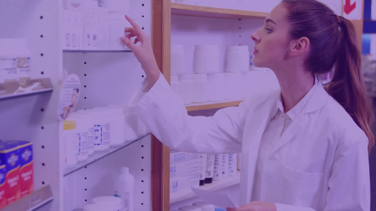 Female pharmacy staff reaching up and selecting boxed product from shelves, presenting to customers