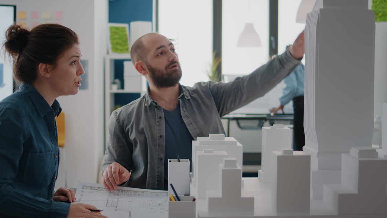 Architects Collaborating on Building Model and Blueprints