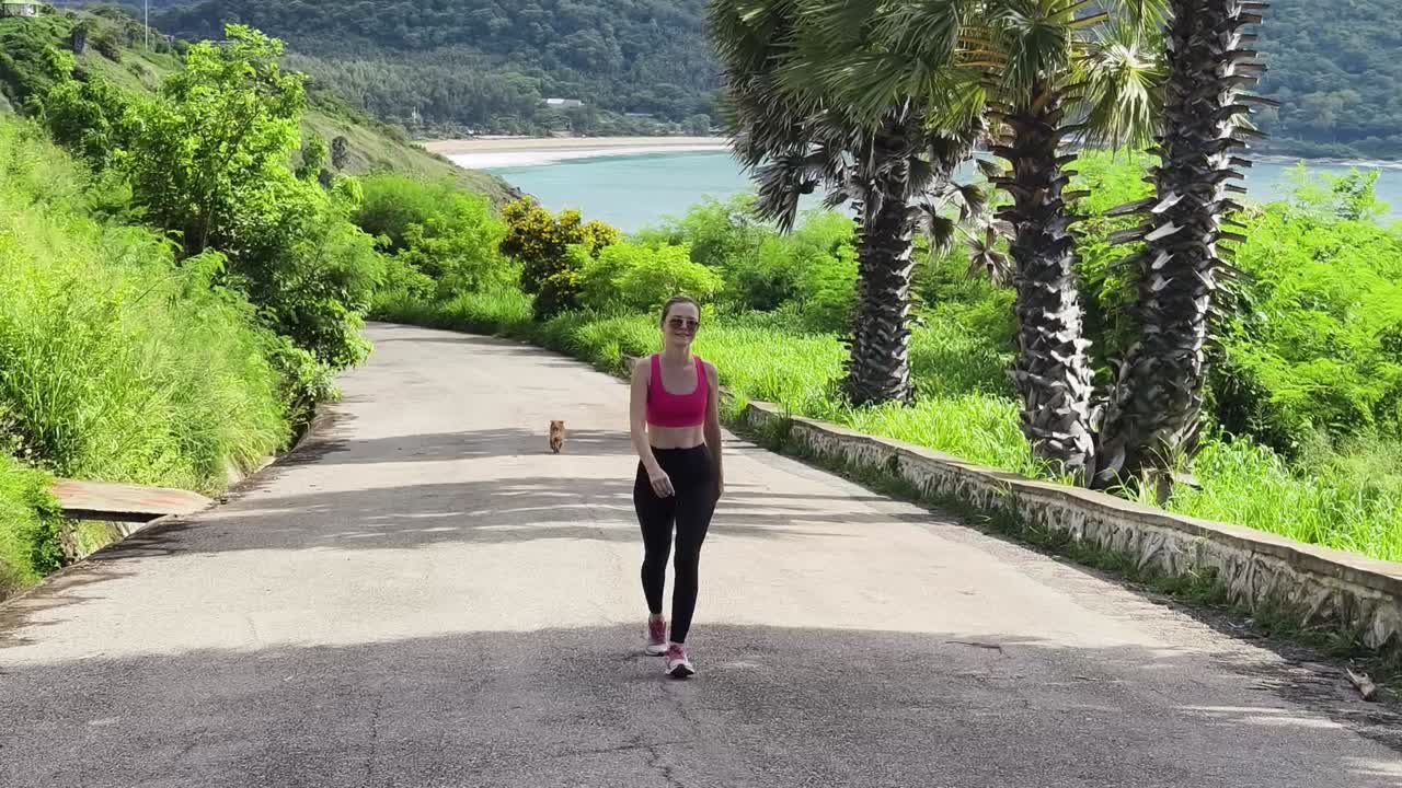 mujer caminando por una pintoresca carretera costera