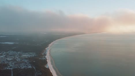 beautiful foggy aerial view of seaside coastline in winter at sunrise, sunset