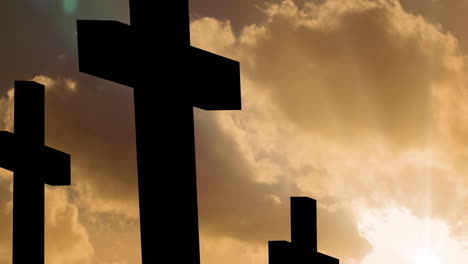 animation of three christian crosses over sun shining on yellow sky with clouds